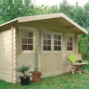 Abri de jardin S8384 installé dans un jardin, idéal pour rangement et aménagement extérieur